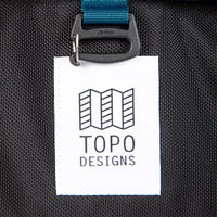 General shot of Topo Designs logo patch on Global Travel Bag Roller durable carry-on convertible laptop backpack rolling suitcase in Navy blue.