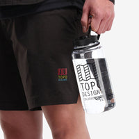 General shot of model holding a Topo Designs Nalgene water bottle.