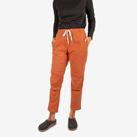 Front model shot of Topo Designs Women's Dirt Shirt & Pants in "Brick" orange.